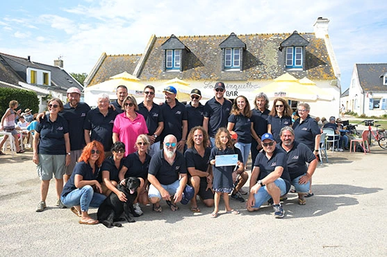 Les membres de l'association et une élève lors de la remise du chèque, devant le bar La Trinquette à Hoëdic